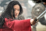 Liu Yifei as Mulan, a woman fighting with a sword, int the Disney movie Mulan