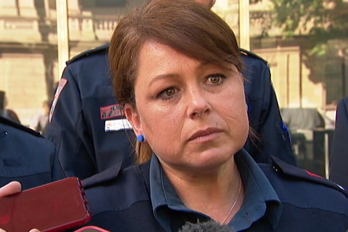 Julie Mullenger, wearing her paramedic's uniform, speaks to media outside court.
