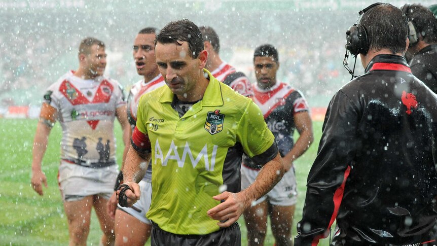 Referee and players leave the SFS in a weather break between the Dragons and Roosters on Anzac Day.