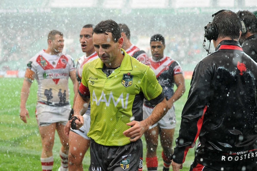 Referee and players leave the SFS in a weather break between the Dragons and Roosters on Anzac Day.