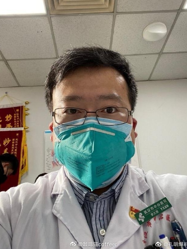 Un uomo che indossa una maschera medica e occhiali si fa un selfie.  Ha i capelli corti e scuri.