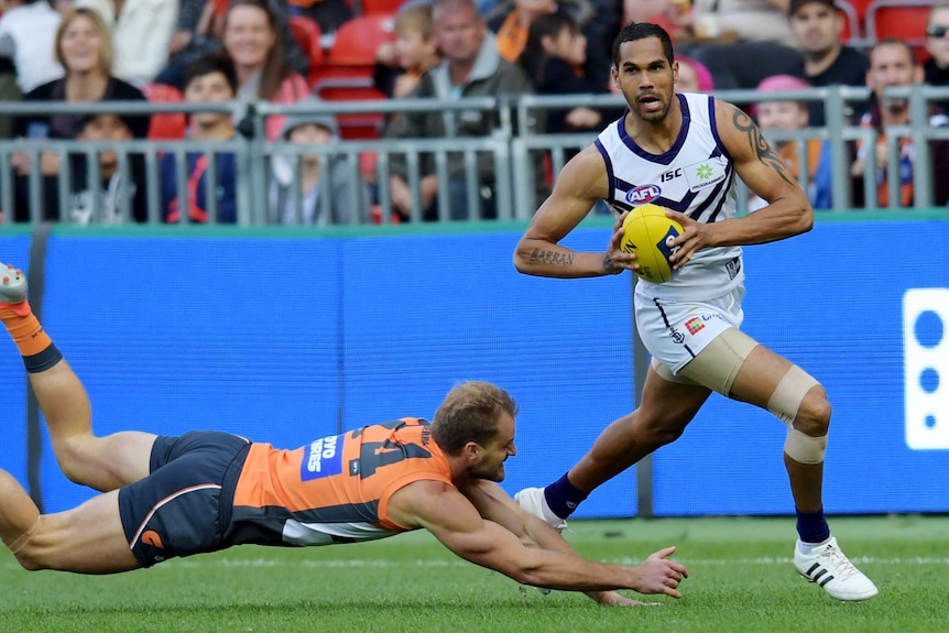Fremantle Dockers forward Shane Yarran eludes a tackle from GWS Giants player Joel Patfull during an AFL game.