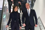 Prince William and Kate descend a set of stairs while chatting 