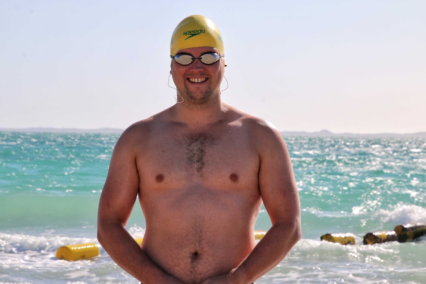 Jeremy McClure, pictured at a Perth beach wearing swimming goggles and hat.