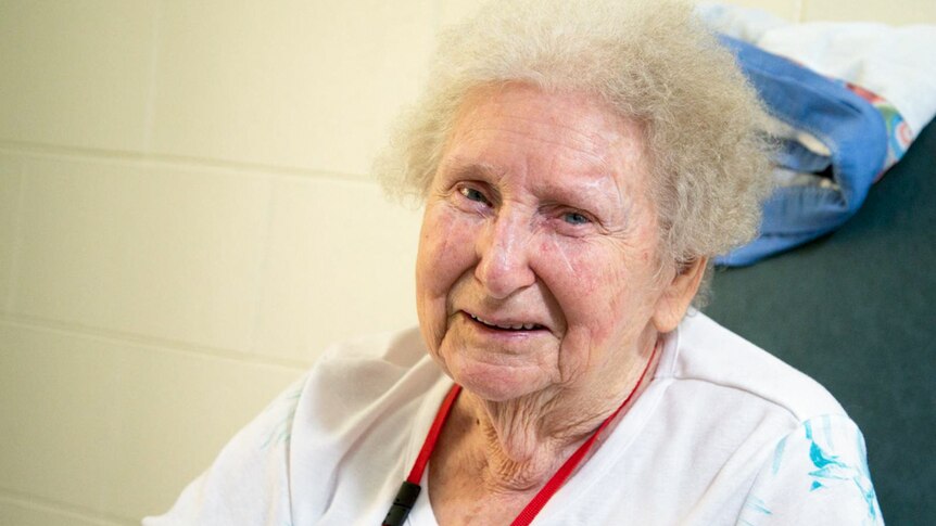 An elderly woman sitting in a chair.