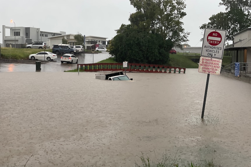 A ute almost completely submerged in floodwater.