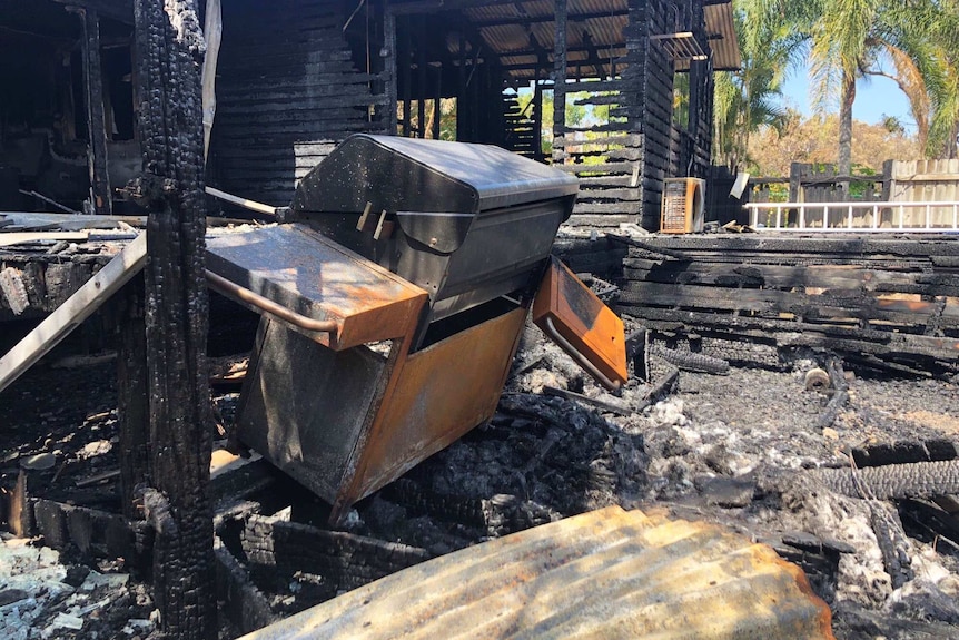 Melted barbeque and charred rear deck and back yard area of the bushfire-destroyed home.