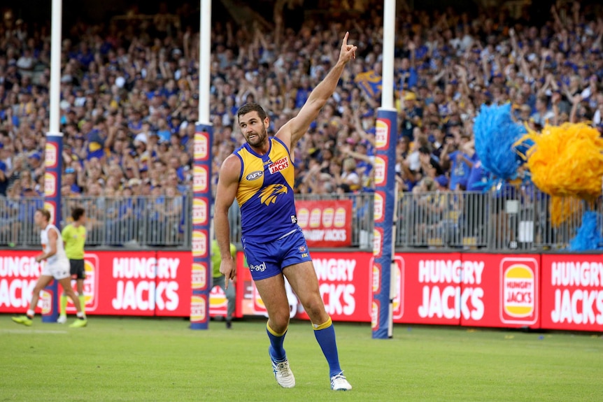 West Coast Eagles forward Jack Darling celebrates a goal with a hand raised in the air.
