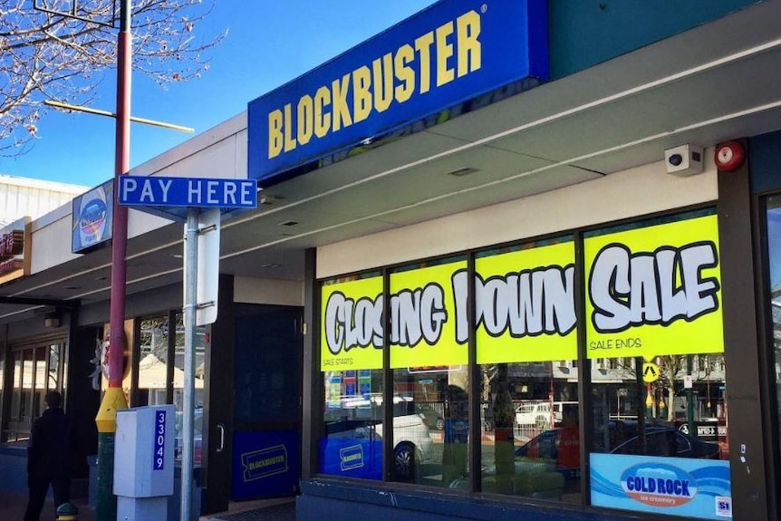 A Blockbuster DVD store with a closing down sale sign out the front.