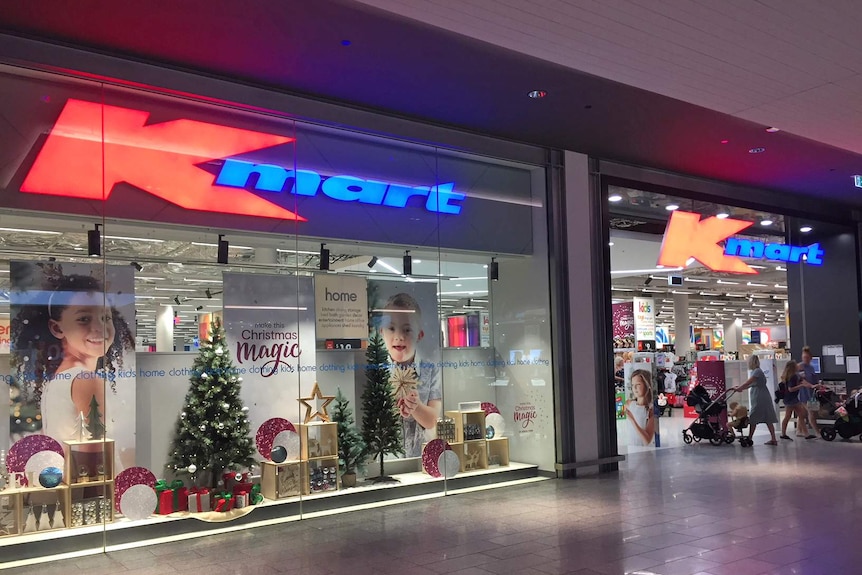 Shoppers enter and leave the Kmart store at Westfield North Lakes. There are christmas decorations in the window.