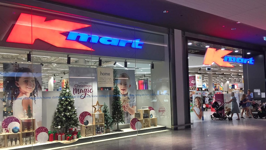 Shoppers enter and leave the Kmart store at Westfield North Lakes. There are christmas decorations in the window.