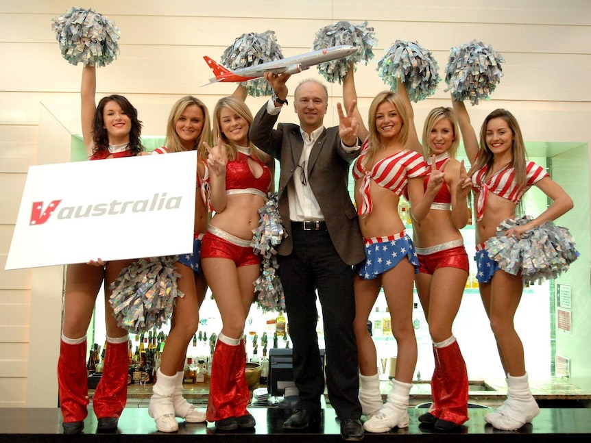 A supplied photo of Virgin Airlines Chief Executive Officer Brett Godfrey posing for photos with cheerleaders in Sydney.