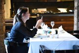 A woman looks at her smart phone in a restaurant