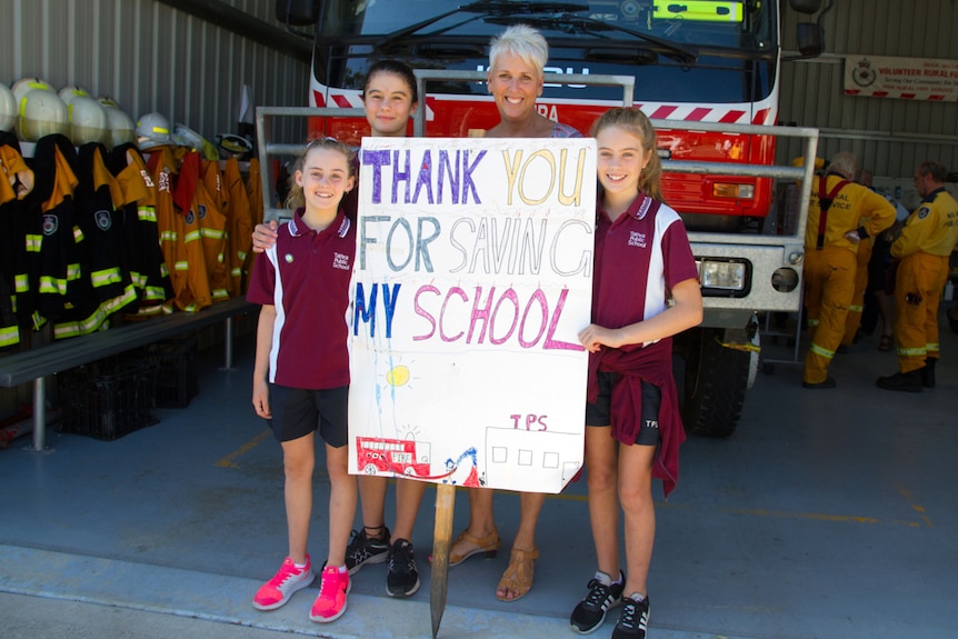 School Principal and 3 students holding sign that says Thank You for Saving our School