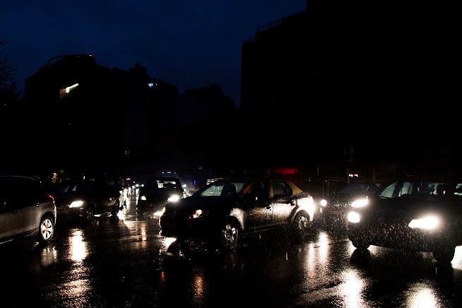Cars drive through an unlit street during a blackout in Buenos Aires, Argentina, Sunday, June 16, 2019.