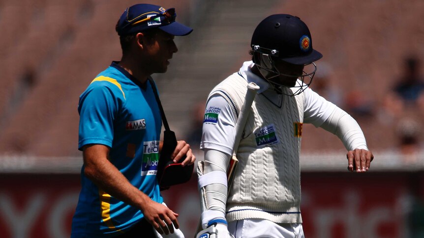 Damaged digit ... Sri Lanka's Kumar Sangakkara (R) walks off with a possibly broken finger.