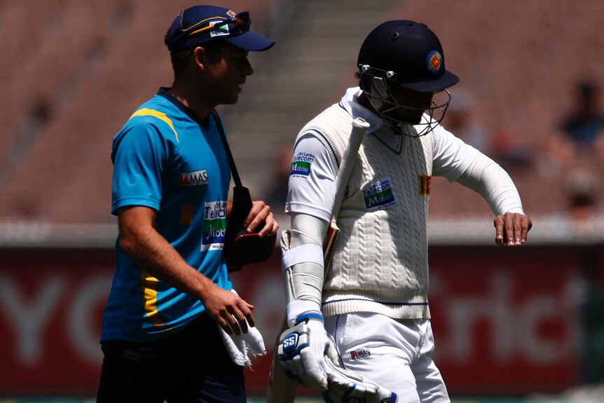Damaged digit ... Sri Lanka's Kumar Sangakkara (R) walks off with a possibly broken finger.