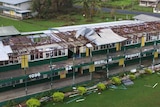Aerial photo showing the roof missing off a primary school building housing several classrooms.