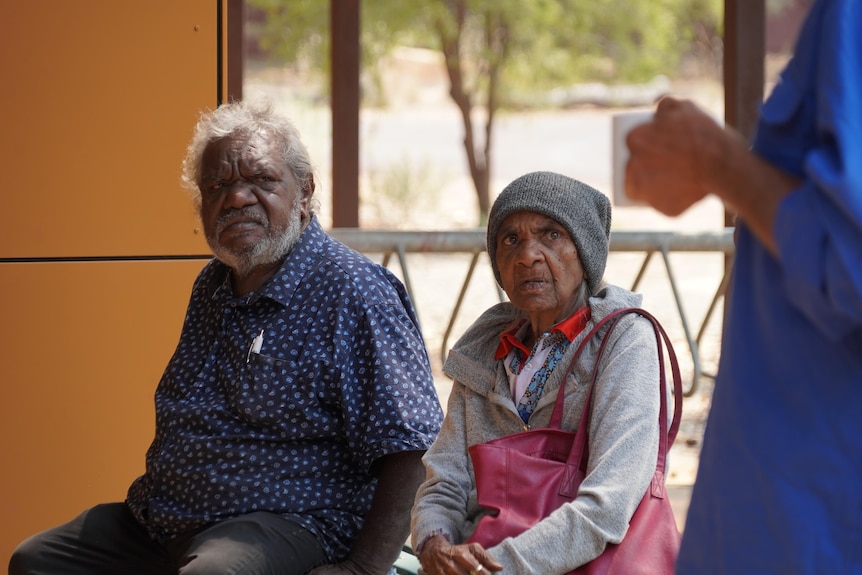 Two older Aboriginal people sitting on a bench