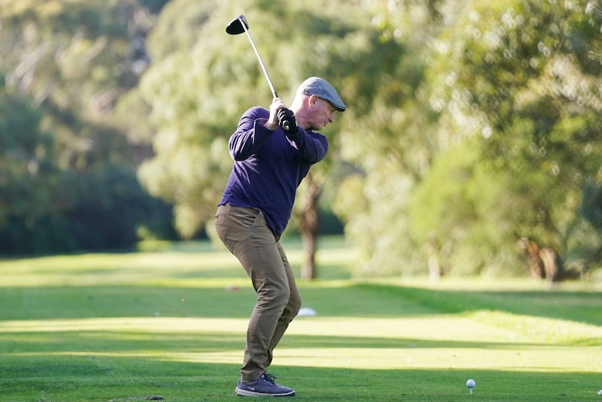 A male golfer takes a swing on a fairway at Brighton Golf Course in Melbourne.