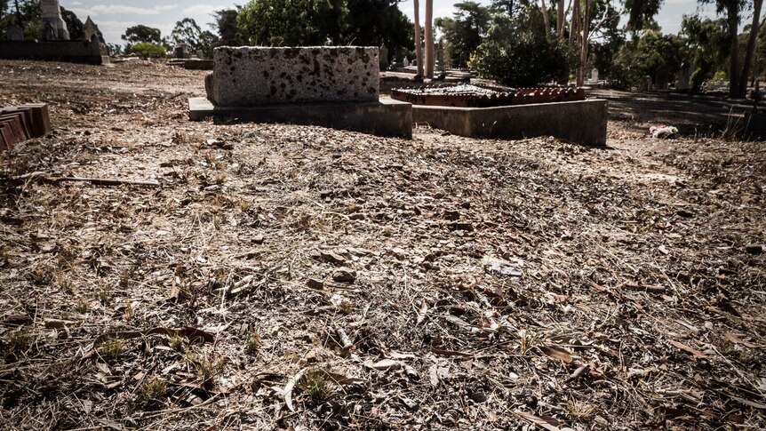 An unmarked grave site in stony red earth