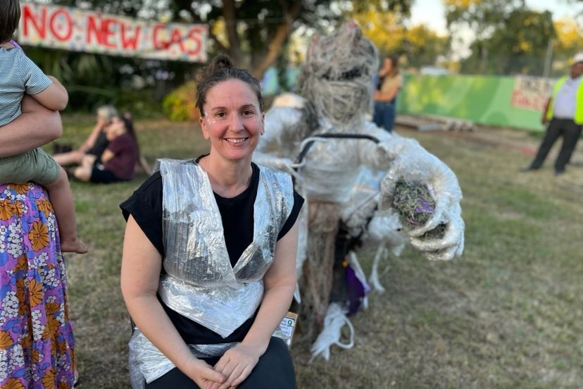 a woman wearing plastic in front of a plastic sculpture