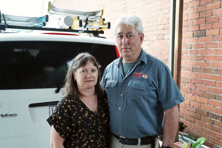 Leanne and Tony Nesci standing in front of a white van, looking at the camera slightly concerned.