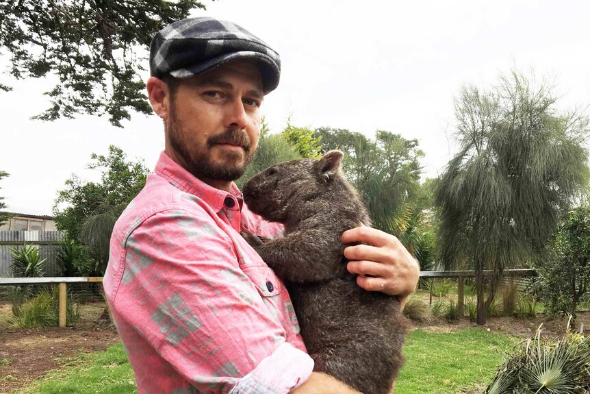 Kelso wildlife carer Brendan Dredge holding Xavier the wombat.