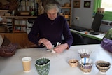 Deborah Cantrill weaving with a coffee cup.