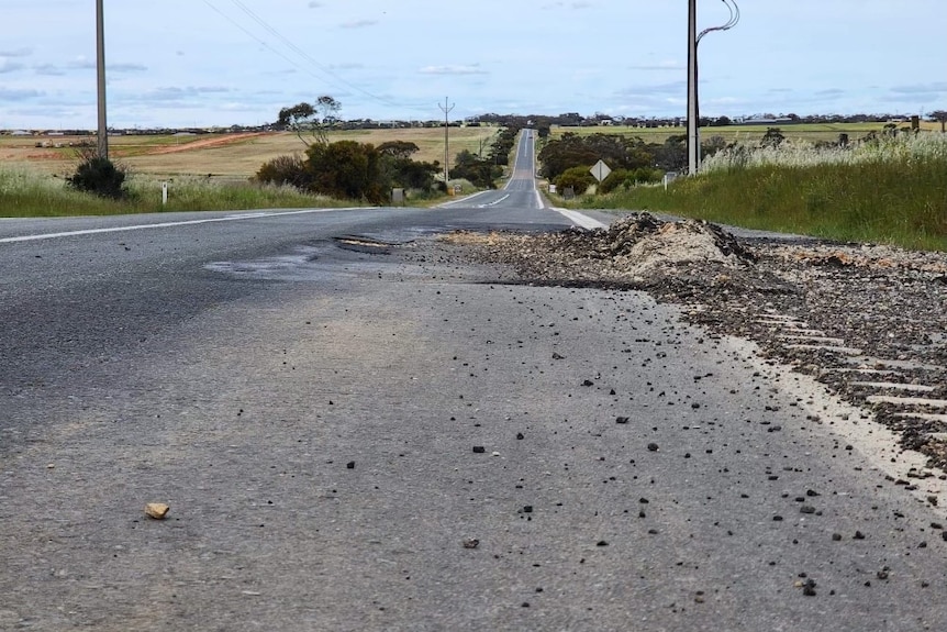 Gravel with a large pothole on the side of Mannum Rd