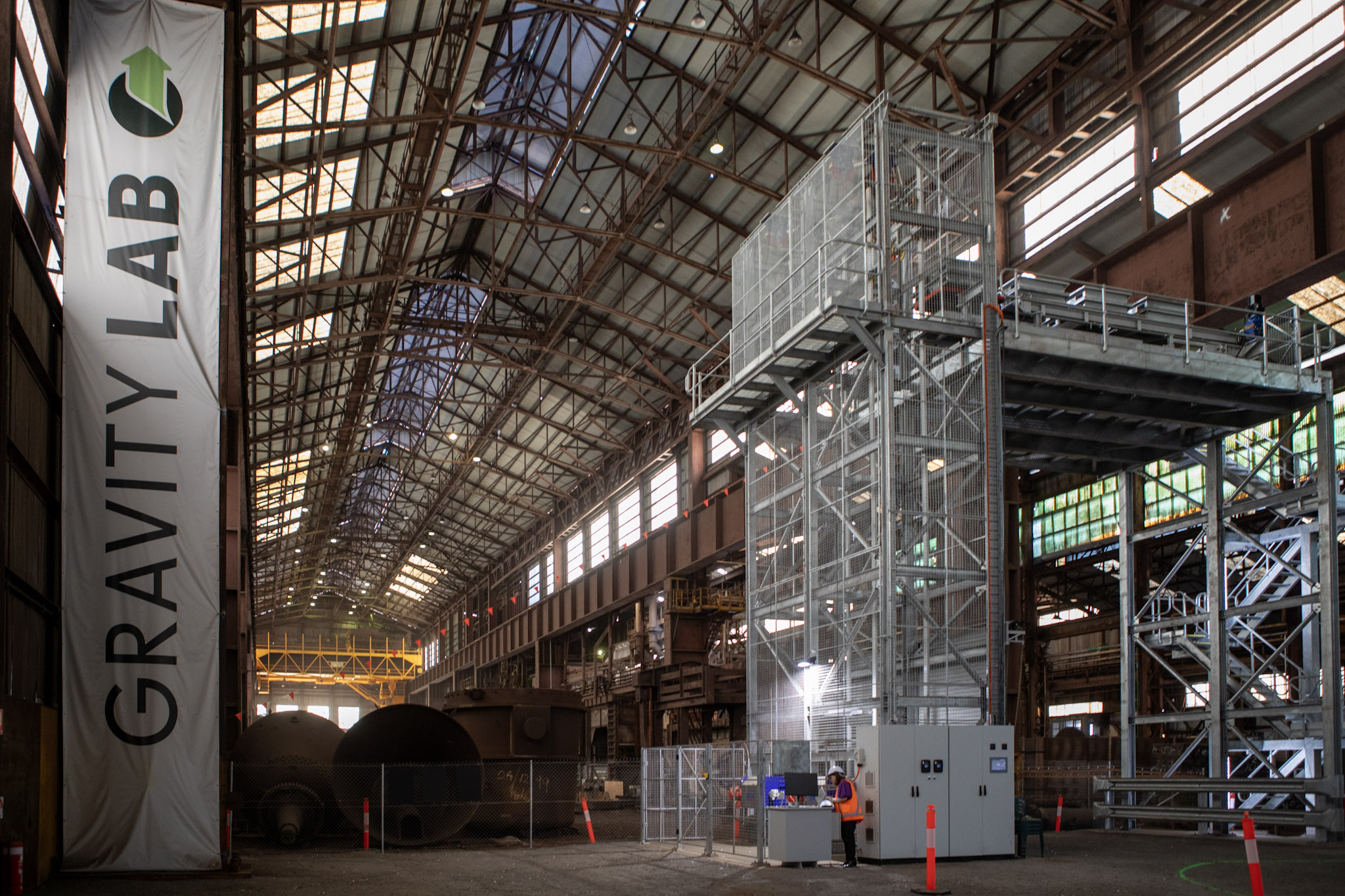 A hangar-like building with a gantry opposite a banner that reads "Gravity Lab".