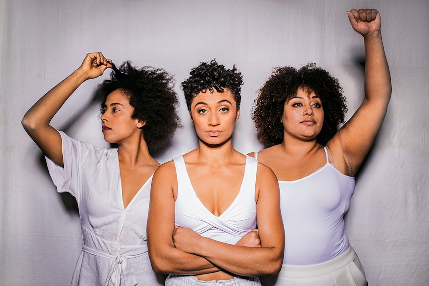 Colour photograph of actors Ayeesha Ash comb in hair, Emily Havea arms crossed and Angela Sullen arm and fist raised.