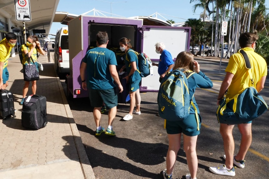 Olympic athletes unloading luggage from a vehicle outside Darwin Airport. 