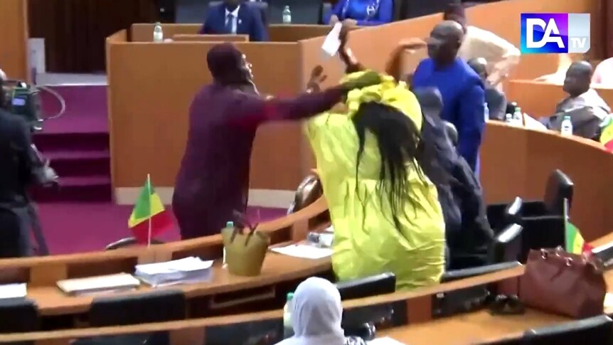 A male lawmaker in Senegal slaps his pregnant female colleague.