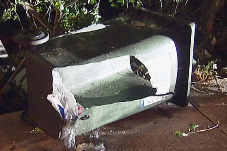 Wheelie bin lying on its side after being hit by car