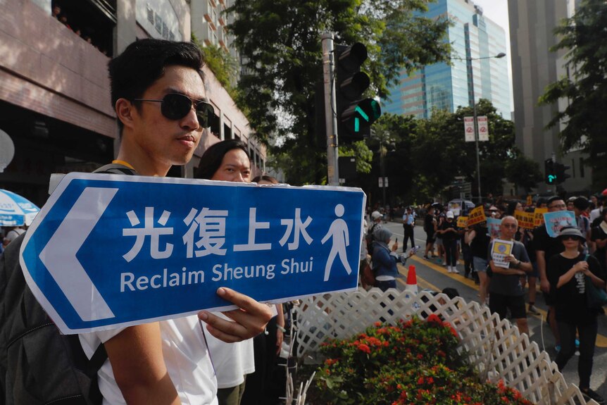 Protester holds placard that reads "Reclaim Sheung Shui".