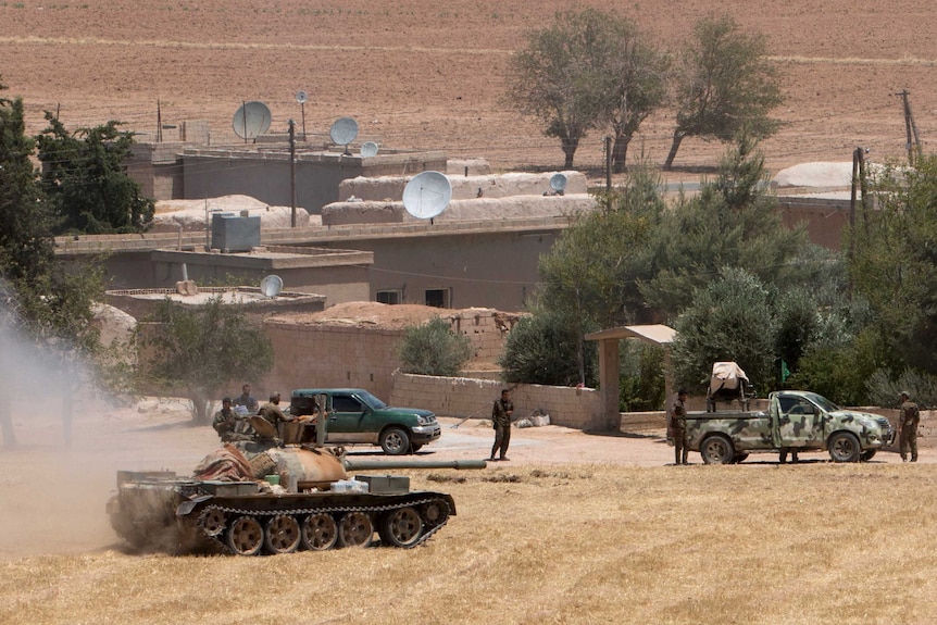 Kurdish fighters gather at the eastern entrance of Tel Abyad, Syria
