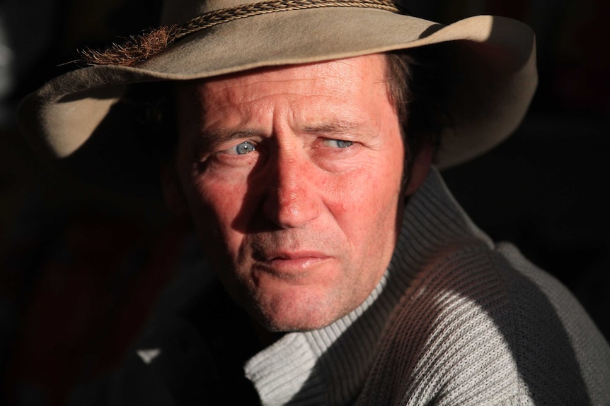 A portrait of Bernie Shakeshaft, who is gazing to the right of the frame in stark sunshine.