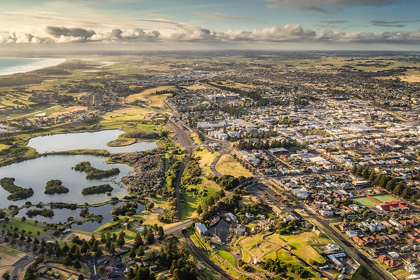 An aerial view of a city and a lake by the ocean.