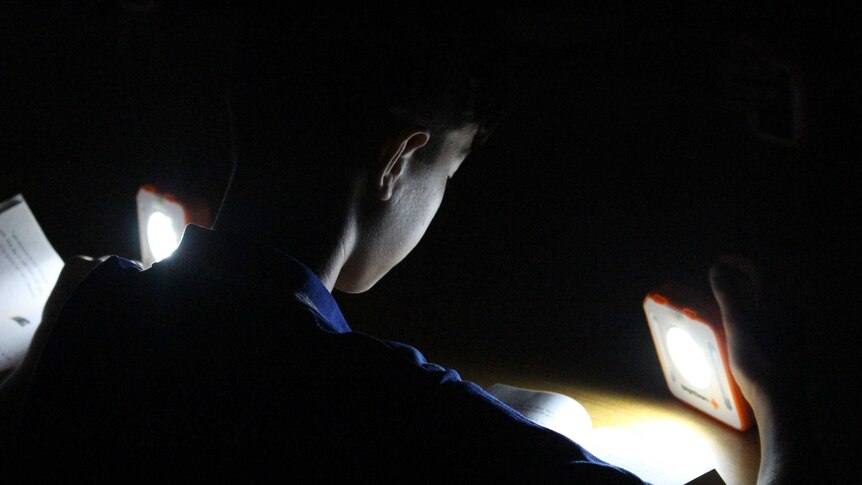A Year 6 student at Amberley District State School reads by solar light