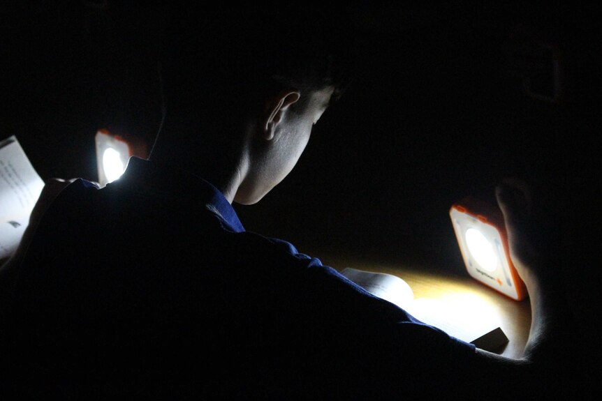 A Year 6 student at Amberley District State School reads by solar light