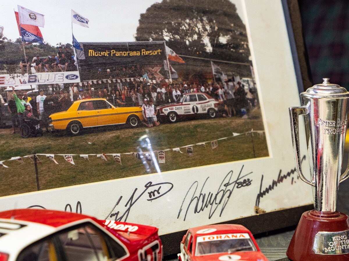 Motor racing memorabilia photograph, cars and trophy.