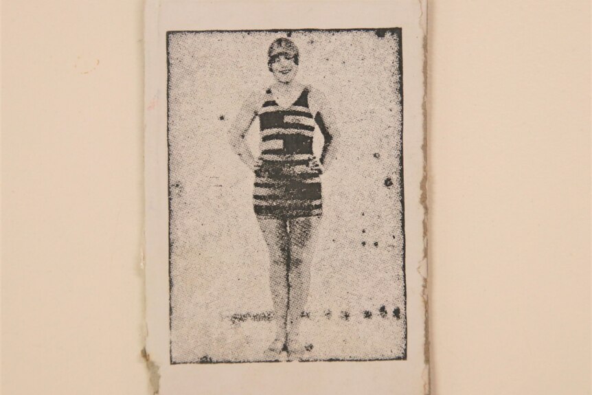 A black and white photo of a women in an old fashioned 1900's bathing costume 