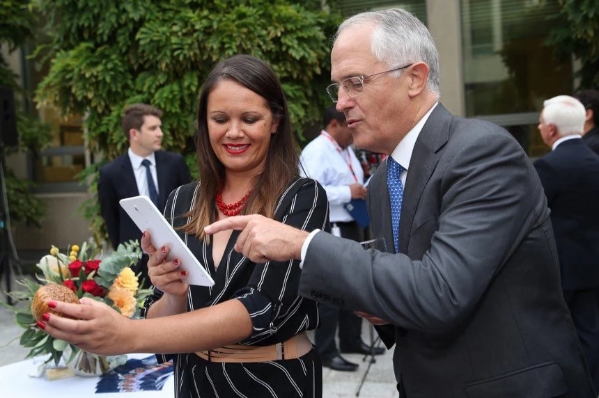 A Mikaela Jade holds at iPad that a Malcom Turnbull looks and points at.