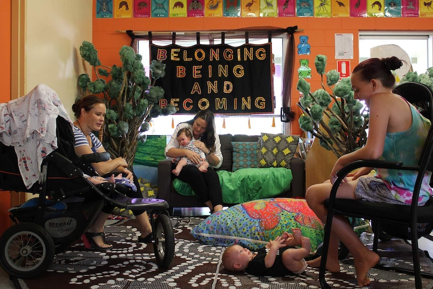 Young mums and their babies in a bright room with toys in Cooktown.