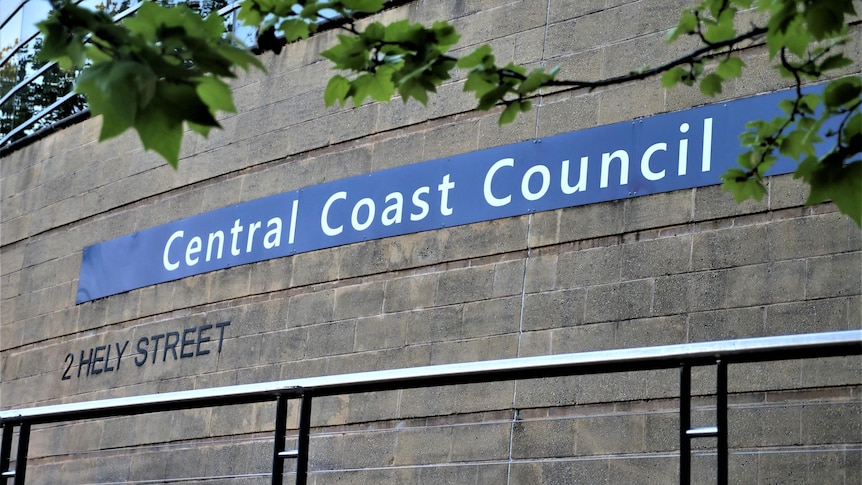 leaves from a tree frame a sign that reads Central Coast Council