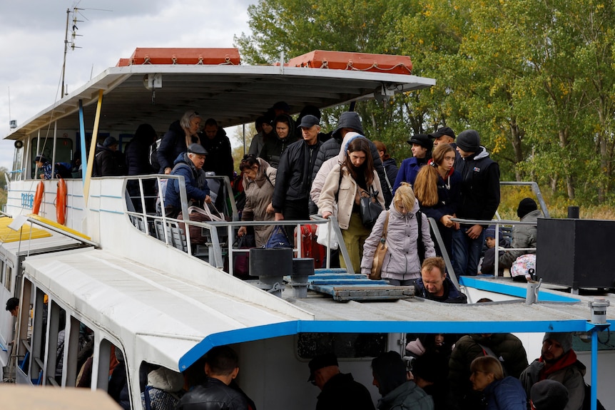 Civilians evacuated from Kherson travel by ferry.