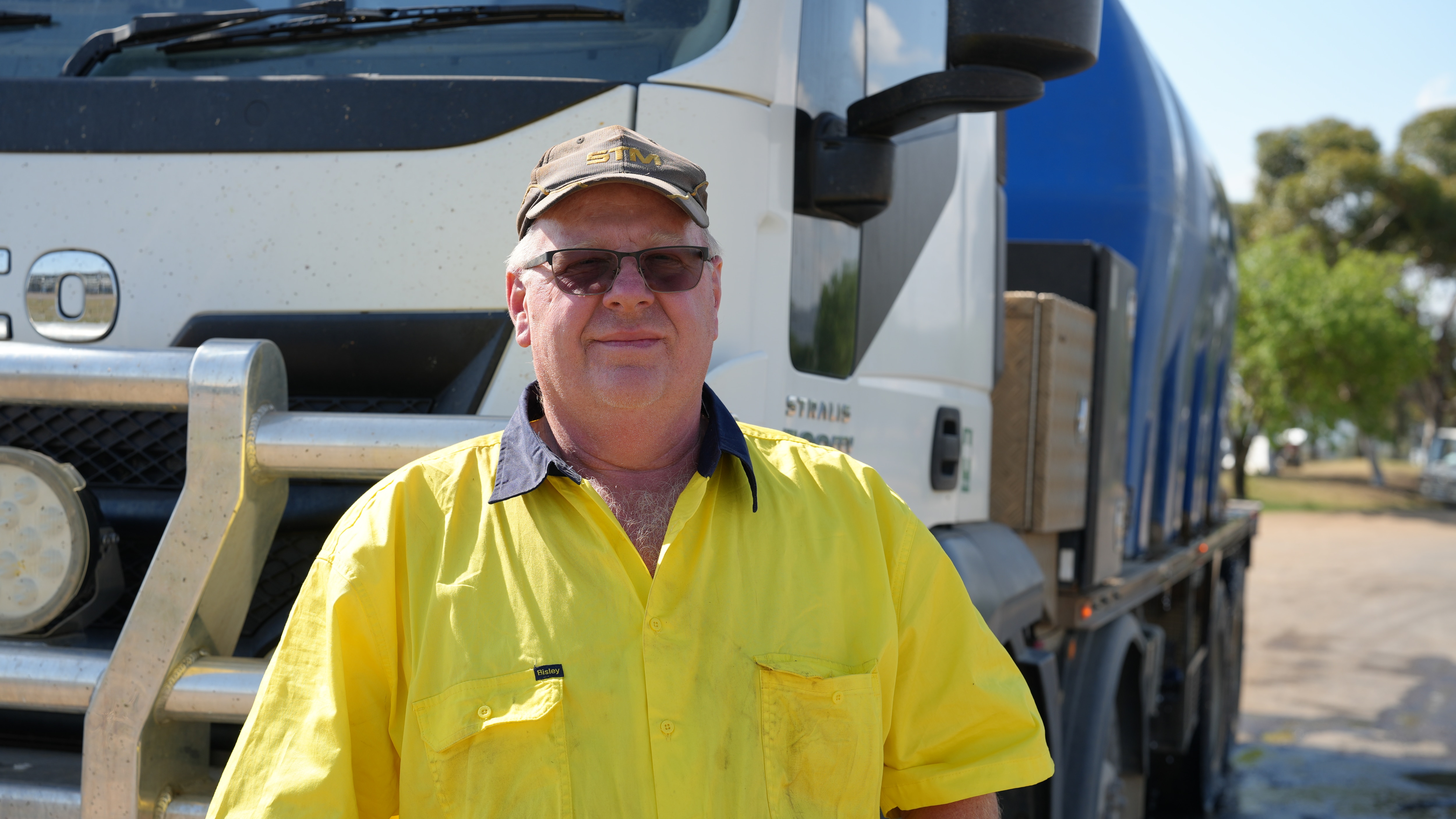 Dave Henry stands in front of his water carting truck