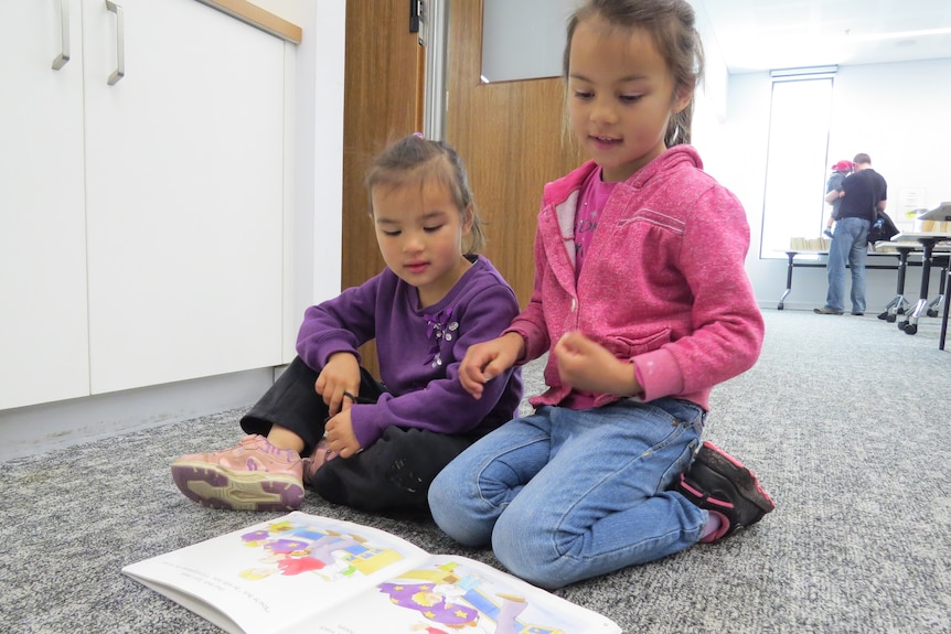 Lexie Zeng reads to her younger sister, Amber.