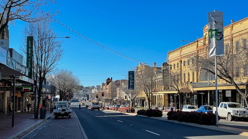 A small town street looking empty with a long empty road